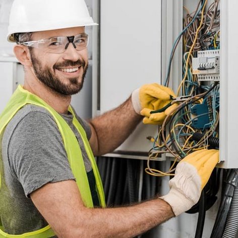 Ein Elektroniker der an einem Verteilerkasten arbeitet