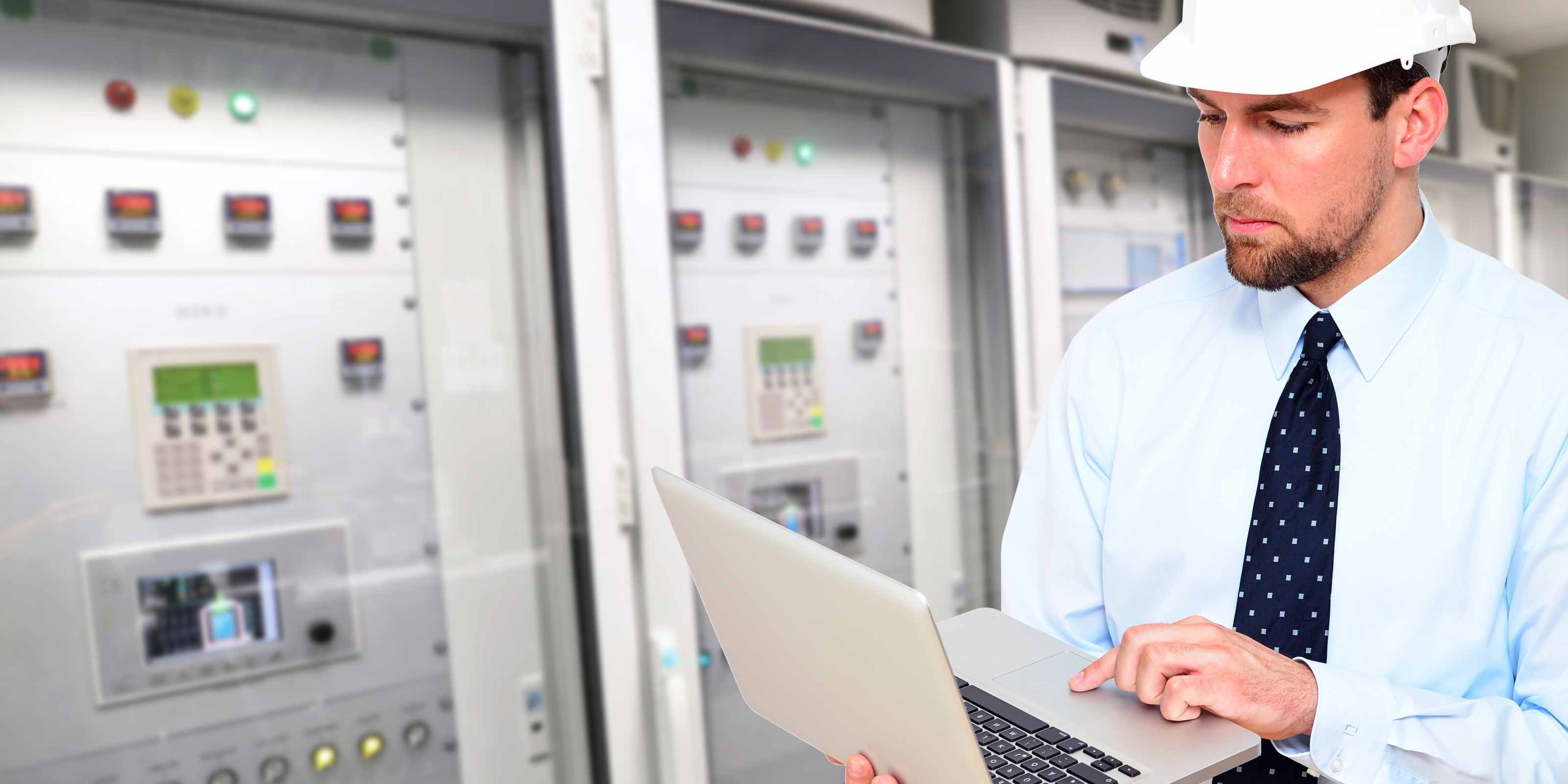 Ein Mann der in Bereitschaftsdienst ist mit einem Laptop und einem Bauhelm