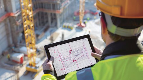 Techniker überwacht und steuert Gebäudesysteme während der Umsetzung in einer Industrieumgebung