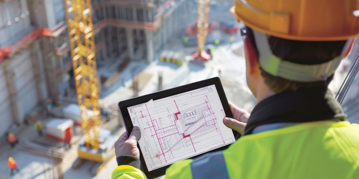 Techniker überwacht und steuert Gebäudesysteme während der Umsetzung in einer Industrieumgebung