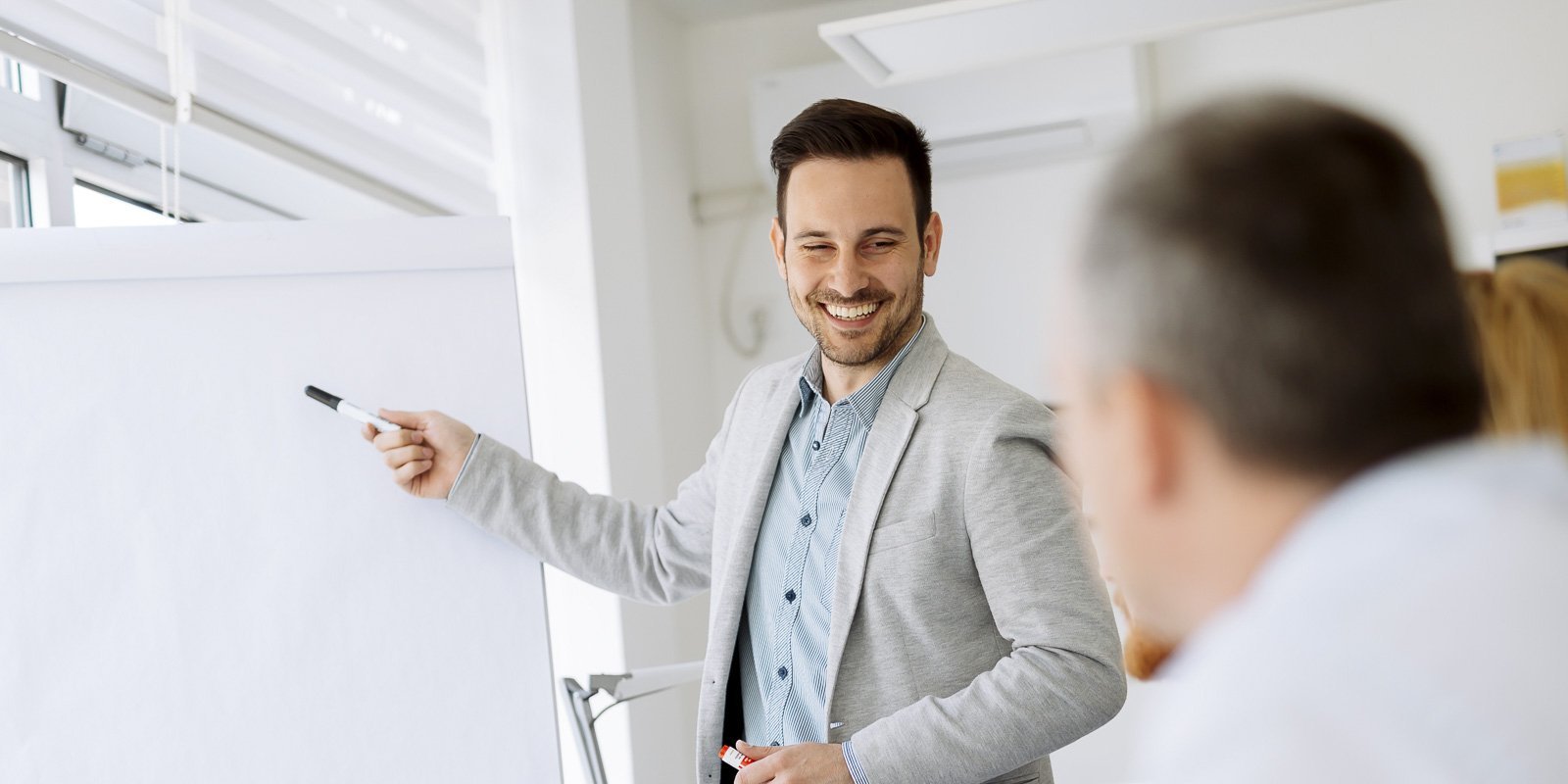 Drei Mitarbeiter und ein Teamleiter der an einem Board steht